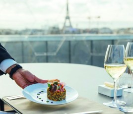 Main d'un serveur avec un plat en restauration à table