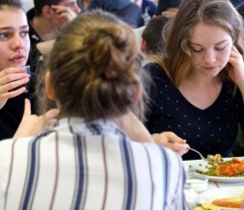 Des élèves femmes mangent à la cantine