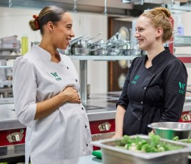 Deux femmes dont une enceinte en tenue de cuisine 