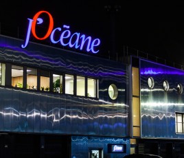 Un entrepôt, de nuit, avec son enseigne bleue et rouge