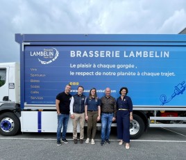 Cinq personnes devant un camion dont la caisse est bleue 
