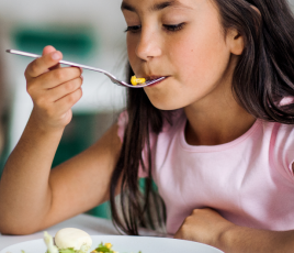 petite fille qui mange à la cantine scolaire