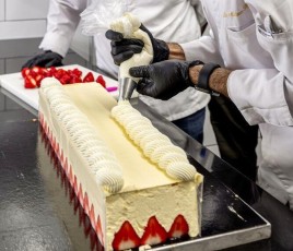 Pâtissier qui réalise un gâteau fraisier