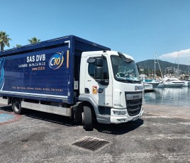 Camion à caisse bleue stationné devant un port