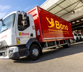 Camion à caisse rouge en gros plan, à moitié sorti d'un garage.