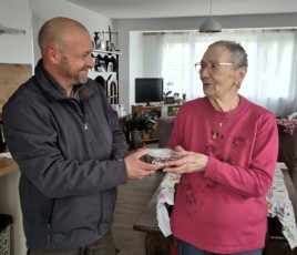 Une personne âgée reçoit une barquette inox avec son repas