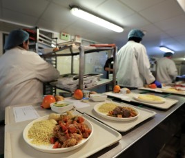 des préparateurs en cuisine sur une ligne de dressage de plateau