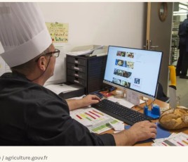 Un chef gérant de restauration collective devant son ordinateur