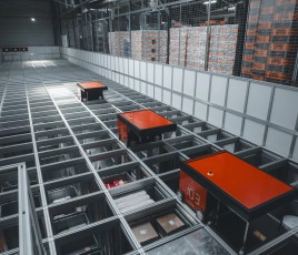 Trois automates rouges en position horizontale sur un meuble de rangement dans un entrepôt 