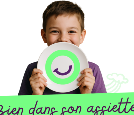 un enfant avec une assiette devant lui