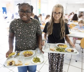 Deux enfants à la cantine avec des plateaux