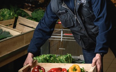 préparateur de commandes avec une cagette de poivrons en mains