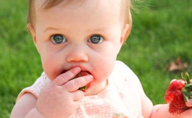 Un bébé qui mange une fraise