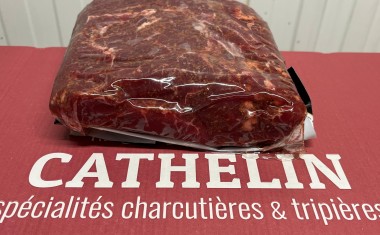 Amas de viande rouge sous film plastique, posé sur un à plat rouge avec le titre Cathelin juste en dessous.