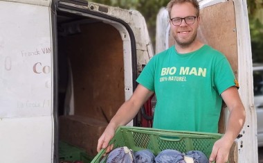 UN LIVREUR AVEC UNE CAGETYTE DE LEGUMES AUDE A TABLE