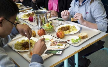 Enfants qui mangent à la cantine scolaire 