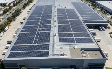 entrepôt de couleur grise couvert de panneaux photovoltaïques, vu du ciel 