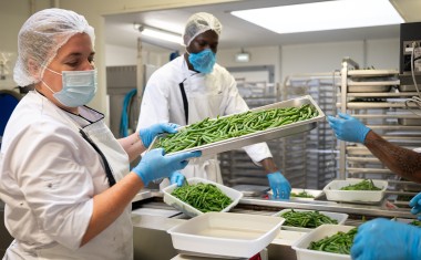 cuisiniers avec plats inox de haricots verts