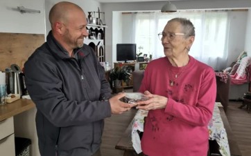 Une personne âgée reçoit une barquette inox avec son repas