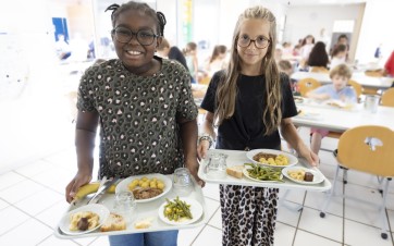 Deux enfants à la cantine avec des plateaux