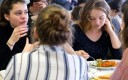 Des élèves femmes mangent à la cantine