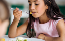 petite fille qui mange à la cantine scolaire