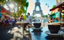 deux tasses de café sur une table, au premier plan, avec la Tour Eiffel au second plan 