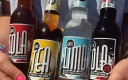 Quatre bouteilles de soft en gros plan tenues par deux mains