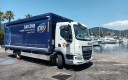 Camion à caisse bleue stationné devant un port