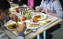 Enfants qui mangent à la cantine scolaire 