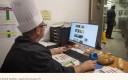 Un chef gérant de restauration collective devant son ordinateur