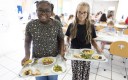 Deux enfants à la cantine avec des plateaux
